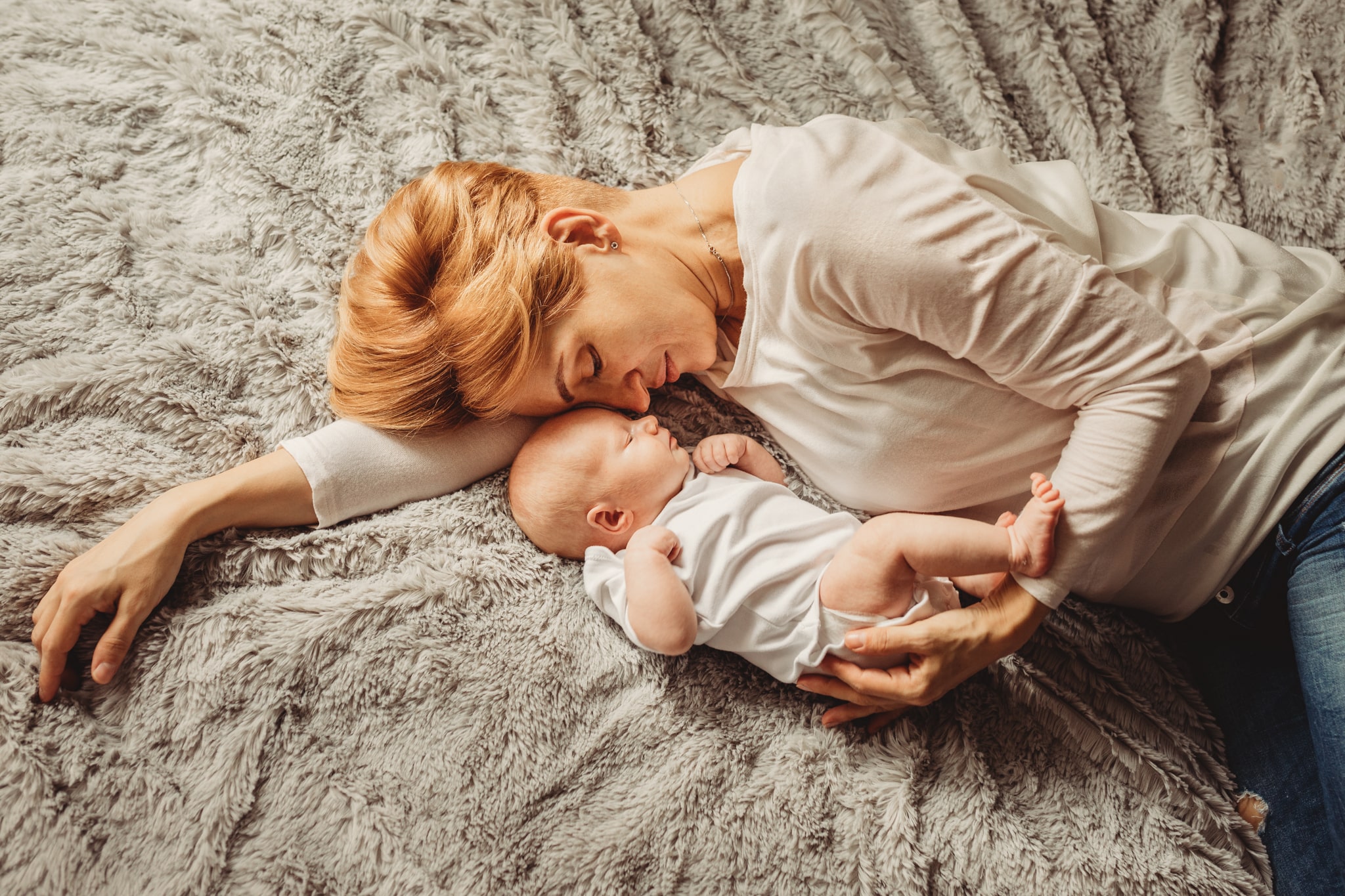 mama przytula noworodka leżąc na lóżku