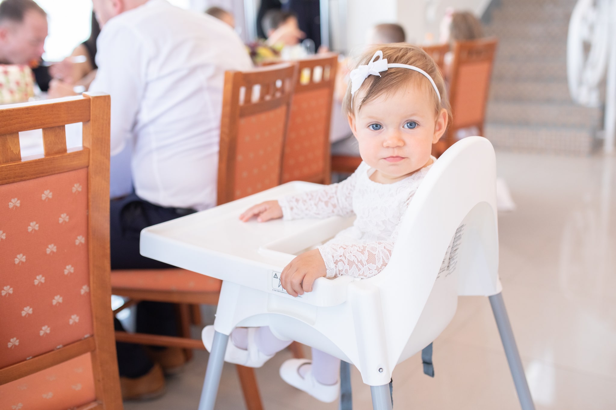 mała dziewczynka siedzi na krzesełku do karmienia 